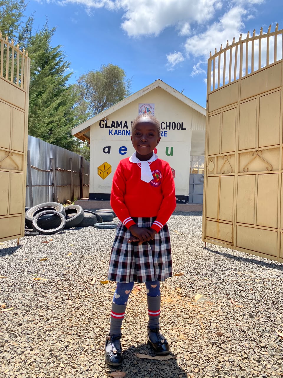 A Glama ECDE pupil standing at the school gate